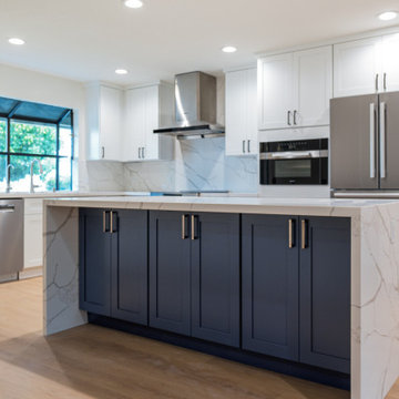 Modern White Shaker Kitchen with Navy Blue Island and Waterfall Quartz Counterto