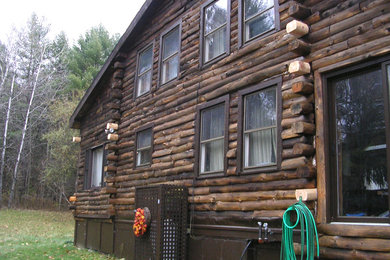This is an example of a medium sized and brown rustic two floor house exterior in Other with wood cladding and a pitched roof.