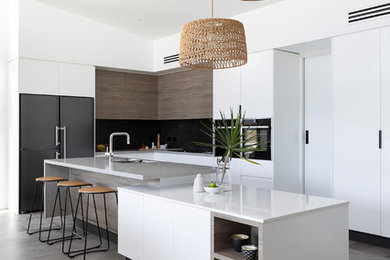 Inspiration for a large contemporary l-shaped open plan kitchen in Brisbane with a single-bowl sink, flat-panel cabinets, white cabinets, quartz benchtops, multi-coloured splashback, ceramic splashback, black appliances, cement tiles, with island, grey floor and grey benchtop.