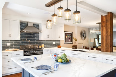 Inspiration for a mid-sized contemporary u-shaped dark wood floor and brown floor open concept kitchen remodel in New York with an undermount sink, shaker cabinets, white cabinets, marble countertops, gray backsplash, subway tile backsplash, stainless steel appliances and an island