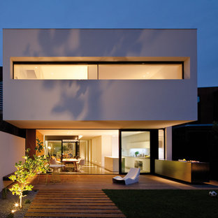 Bild på ett stort funkis vitt betonghus, med två våningar och platt tak