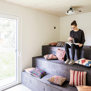 Inspiration pour une petite salle de cinéma minimaliste avec un mur blanc, béton au sol et un sol gris.