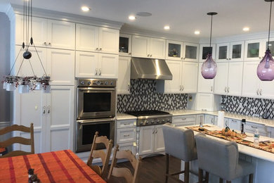 ボストンにある広いおしゃれなキッチン (落し込みパネル扉のキャビネット、白いキャビネット、クオーツストーンカウンター、マルチカラーのキッチンパネル、セラミックタイルのキッチンパネル、シルバーの調理設備、白いキッチンカウンター) の写真