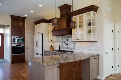This is an example of a large traditional l-shaped open plan kitchen in Minneapolis with a farmhouse sink, recessed-panel cabinets, grey cabinets, quartz benchtops, beige splashback, stone tile splashback, stainless steel appliances and medium hardwood floors.