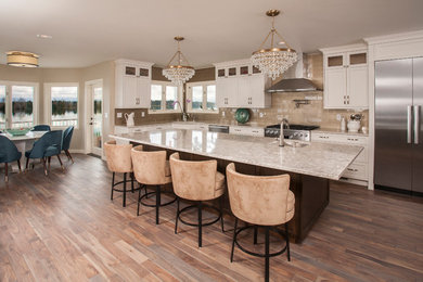 Inspiration for a large 1960s medium tone wood floor and brown floor open concept kitchen remodel in Seattle with a single-bowl sink, shaker cabinets, white cabinets, quartz countertops, beige backsplash, glass tile backsplash, stainless steel appliances, an island and beige countertops