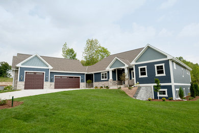 Expansive one-storey blue house exterior in Milwaukee with mixed siding and a shingle roof.