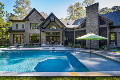 Inspiration for a mid-sized contemporary backyard custom-shaped lap pool in Raleigh with a water feature and concrete pavers.