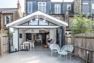 Photo of a mid-sized scandinavian one-storey white house exterior in London with a gable roof.