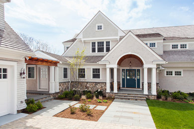 Large beach style white two-story wood exterior home photo in Boston