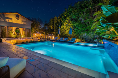 Inspiration for a mid-sized contemporary backyard rectangular lap pool fountain remodel in Orange County with decking