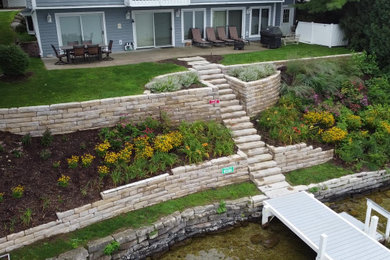 Photo of a large rustic full sun hillside retaining wall landscape in Milwaukee.