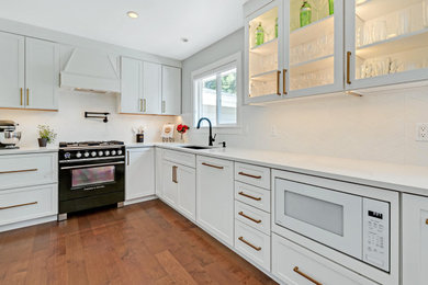 Eat-in kitchen - mid-sized transitional l-shaped medium tone wood floor eat-in kitchen idea in Portland with shaker cabinets, white cabinets, quartzite countertops, white backsplash, mosaic tile backsplash and white countertops