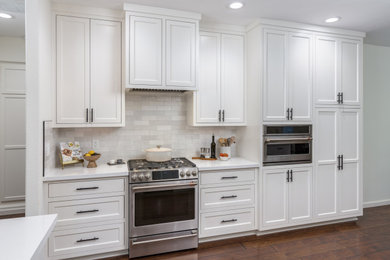Open concept kitchen - mid-sized transitional galley brown floor open concept kitchen idea in Other with an undermount sink, shaker cabinets, white cabinets, quartz countertops, white backsplash, subway tile backsplash, stainless steel appliances, a peninsula and white countertops