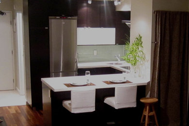 Eat-in kitchen - contemporary u-shaped eat-in kitchen idea in Vancouver with an undermount sink, flat-panel cabinets, dark wood cabinets, quartz countertops, green backsplash, glass tile backsplash and stainless steel appliances