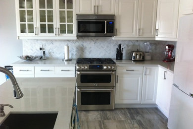 Eat-in kitchen - traditional l-shaped marble floor and gray floor eat-in kitchen idea in Toronto with an undermount sink, raised-panel cabinets, white cabinets, gray backsplash, stone tile backsplash, stainless steel appliances and an island
