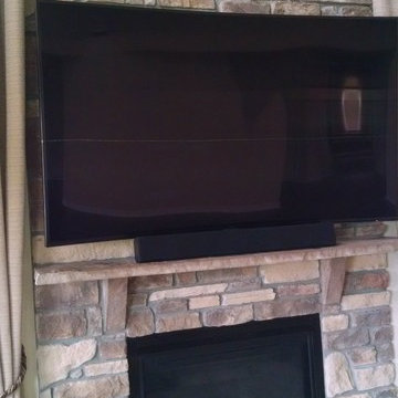 TV wall mount over stone fireplace