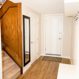 Diseño de sótano con ventanas clásico, de tamaño medio, con suelo vinílico, chimeneas suspendidas, marco de chimenea de metal, suelo marrón y paredes grises