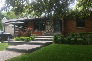 Large 1960s one-story brick exterior home idea in Montreal