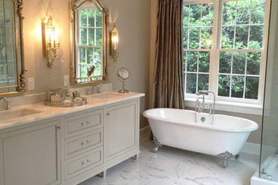 This is an example of a large traditional master bathroom in Atlanta with recessed-panel cabinets, beige cabinets, granite benchtops, a claw-foot tub, a corner shower, gray tile, white tile, ceramic tile, beige walls, marble floors and an undermount sink.