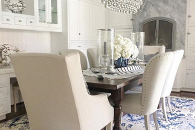 Enclosed dining room - mid-sized traditional medium tone wood floor and brown floor enclosed dining room idea in Orange County with white walls and a stone fireplace