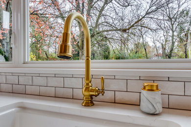 Inspiration for a large timeless vinyl floor kitchen remodel in St Louis with an undermount sink, white cabinets, quartz countertops, white backsplash, subway tile backsplash, white appliances, an island and white countertops