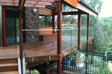 Photo of a large modern balcony in Sydney with a roof extension.