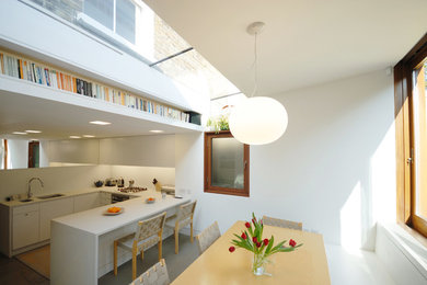 Design ideas for a contemporary kitchen/dining combo in London with white walls.