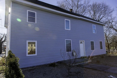 Inspiration for a large modern blue two-story vinyl exterior home remodel in Other with a mixed material roof