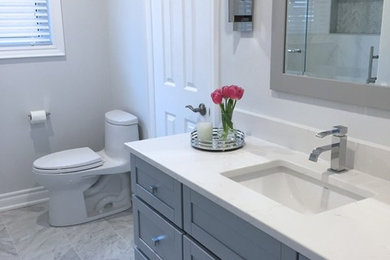Trendy white tile and marble tile marble floor and gray floor bathroom photo in Toronto with shaker cabinets, gray cabinets, a one-piece toilet, blue walls, an undermount sink and quartz countertops