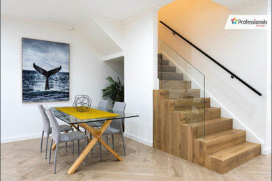 Ejemplo de escalera recta actual pequeña con escalones de madera, contrahuellas de madera, barandilla de metal y panelado