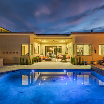 Contemporary Backyard Pool with Tiled Water Feature, Rim Flow Spa, & Fire Pit