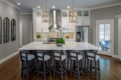 Example of a 1960s single-wall dark wood floor and brown floor open concept kitchen design in Other with a single-bowl sink, shaker cabinets, white cabinets, quartzite countertops, blue backsplash, glass sheet backsplash, stainless steel appliances, an island and white countertops