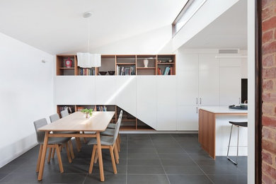 Inspiration for a small contemporary kitchen/dining combo in Melbourne with white walls, ceramic floors and a standard fireplace.