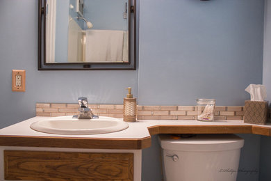 Example of a small classic multicolored tile and stone tile porcelain tile bathroom design in Other with raised-panel cabinets, light wood cabinets, laminate countertops and a one-piece toilet
