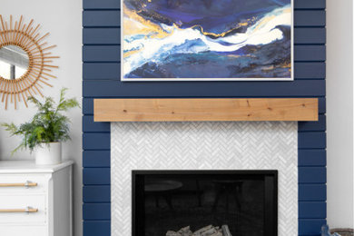 Modelo de salón marinero de tamaño medio con paredes azules, suelo de baldosas de cerámica, todas las chimeneas, marco de chimenea de baldosas y/o azulejos y televisor colgado en la pared