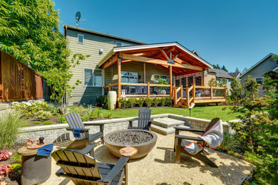Modelo de patio contemporáneo de tamaño medio en patio trasero con brasero y adoquines de hormigón