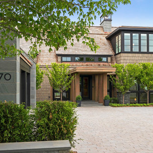 Создайте стильный интерьер: огромный, трехэтажный фасад дома коричневого цвета в стиле модернизм с облицовкой из камня и мансардной крышей - последний тренд