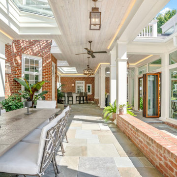 Covered patio dining beside the brick wall with the cabana glass door beyond
