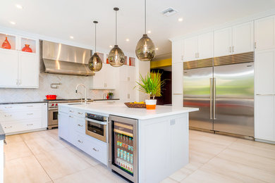 Mid-sized trendy u-shaped porcelain tile and beige floor eat-in kitchen photo in Los Angeles with a single-bowl sink, shaker cabinets, gray cabinets, quartz countertops, white backsplash, stainless steel appliances and an island