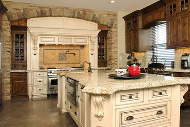 Inspiration for a timeless l-shaped concrete floor and beige floor enclosed kitchen remodel in Denver with an undermount sink, raised-panel cabinets, beige cabinets, granite countertops, beige backsplash, ceramic backsplash, stainless steel appliances and an island