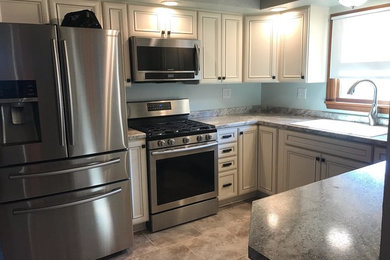 Eat-in kitchen - mid-sized traditional u-shaped eat-in kitchen idea in Other with a double-bowl sink, recessed-panel cabinets, white cabinets, laminate countertops, stainless steel appliances and a peninsula