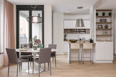 Zweizeilige, Mittelgroße Moderne Wohnküche mit Halbinsel, flächenbündigen Schrankfronten, weißen Schränken, Arbeitsplatte aus Holz, Küchenrückwand in Weiß, hellem Holzboden, beigem Boden und brauner Arbeitsplatte in Berlin