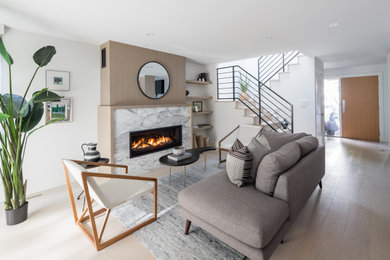 This is an example of a mid-sized contemporary formal open concept living room in Vancouver with white walls, light hardwood floors, a ribbon fireplace, a stone fireplace surround, no tv and beige floor.