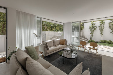 This is an example of a modern living room in Sydney with white walls and grey floor.