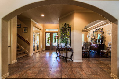 Large elegant ceramic tile entryway photo in Austin with beige walls and a dark wood front door