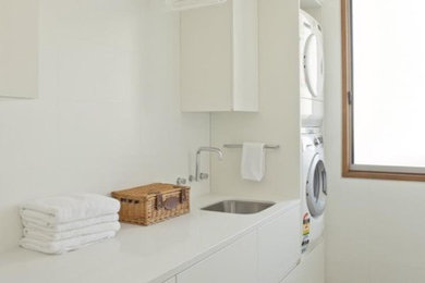 Photo of a mid-sized contemporary laundry room in Melbourne with an undermount sink, white cabinets, quartz benchtops and porcelain floors.
