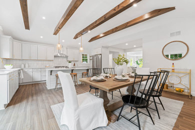 Imagen de comedor de cocina de estilo americano con paredes blancas, suelo de madera en tonos medios y vigas vistas