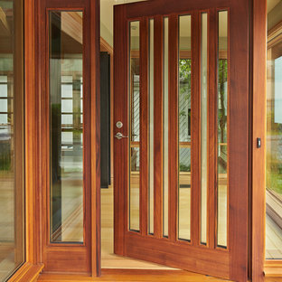 На фото: входные двери в современном стиле с светлым паркетным полом, одностворчатой входной дверью и входной дверью из дерева среднего тона