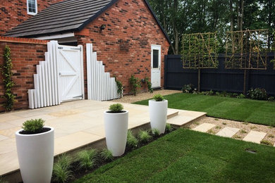 Small contemporary garden in Sandbach. Sawn sandstone paving and pleached trees.
