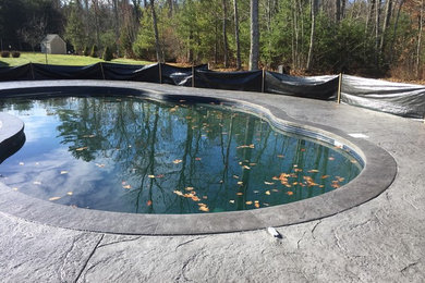Mid-sized trendy backyard stamped concrete and custom-shaped pool photo in Portland Maine
